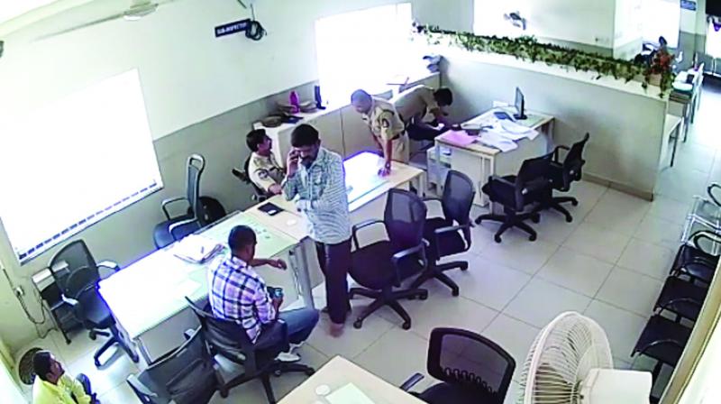 A screen grab of the police CCTV footage shows Bheem Singh talking to his family using the SIs mobile phone. (Photo: DC)