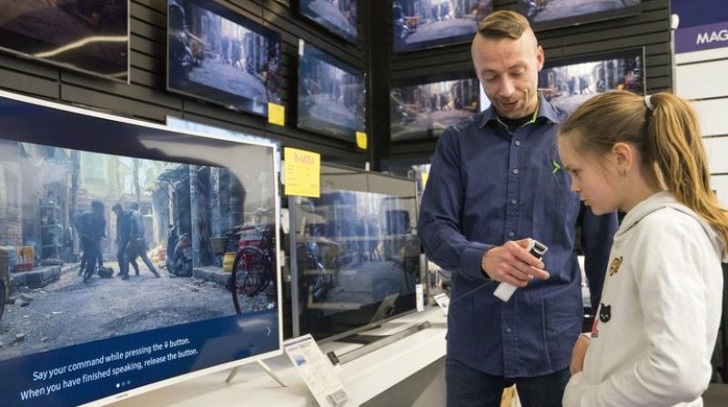 In this photo taken Saturday, April 15, 2017, Salome Sigurjonsdottir, 10, tests a voice-controlled television in an electronics store in Reykjavik. Sales assistant Einar Dadi said none of his TVs understood Icelandic. The revered Icelandic language, seen by many as a source of identity and pride, is being undermined by the widespread use of English both for mass tourism and in the voice-controlled artificial intelligence devices coming into vogue. (AP Photo/Egill Bjarnason)