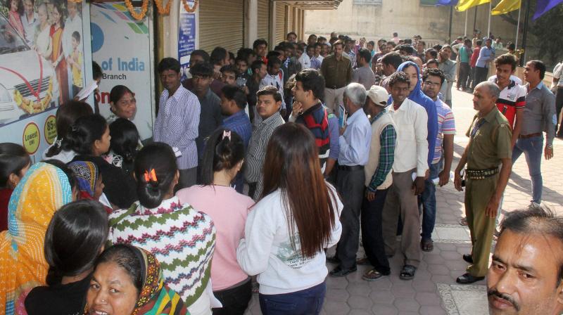 People queue up outside a bank to exchange their old Rs 1000 and Rs 500 currency notes in Gurugram. (Photo: PTI)