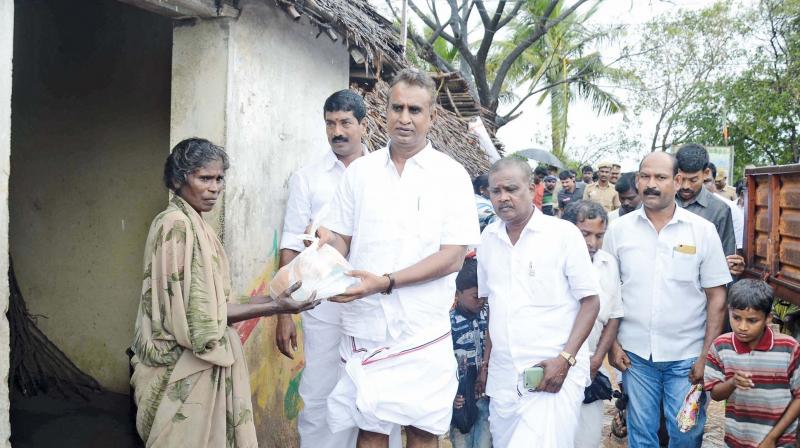 State minister S.P. Velumani distributes relief materials to affected people at Nagapatti-nam district on Tuesday. (Photo: DC)
