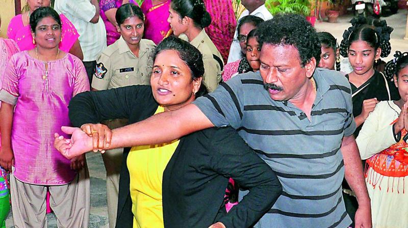 Trainers V. Lakshmi and Ravi give tips to constables, women and girls on self-defence at the Vasavya Mahila Kendram in Vijayawada on Wednesday. (Photo: Deccan Chronicle)