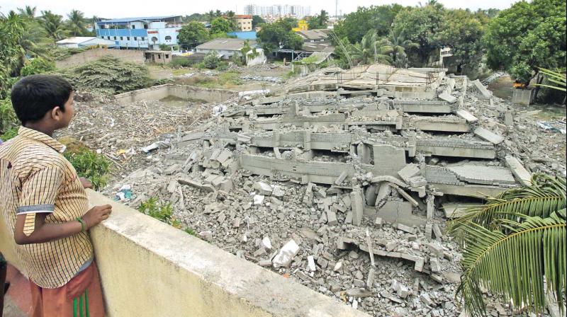 A boy looks at the rubble of Belief tower of Prime Sristi builders brought down in a controlled implosion on Wednesday evening. (Photo: DC)