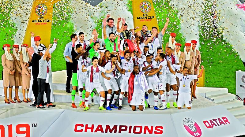 Qatar players celebrate with the trophy after winning the AFC Asian Cup final against Japan at the Mohammed Bin Zayed Stadium in Abu Dhabi on Friday.	(Photo: AFP)