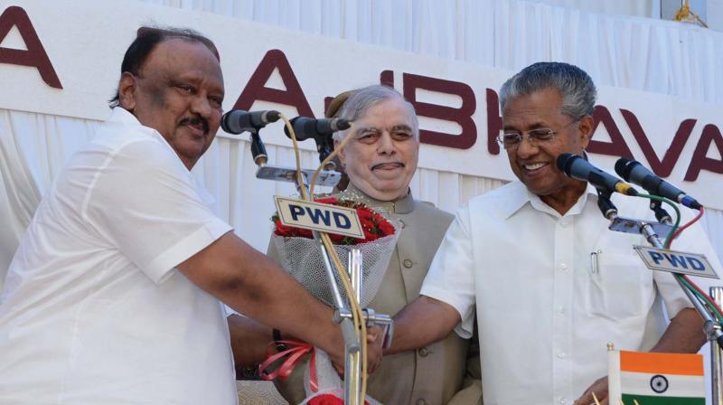 Chief Minister Pinarayi Vijayan congratulates Thomas Chandy after the swearing-in ceremony at the  Raj Bhavan in Thiruvananthapuram on Saturday. Governor P. Sathasivam is also seen. (Photo:  DC)