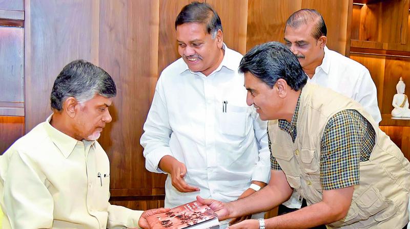 Photographer T. Srinivasa Reddy presents a book Natures Fury Revisiting The Tidal Wave 1977 to Chief Minister N. Chandrababu Naidu at the Secretariat on Tuesday. Deputy Speaker Mandali Buddhaprasad and others are also seen. (Photo: DC)
