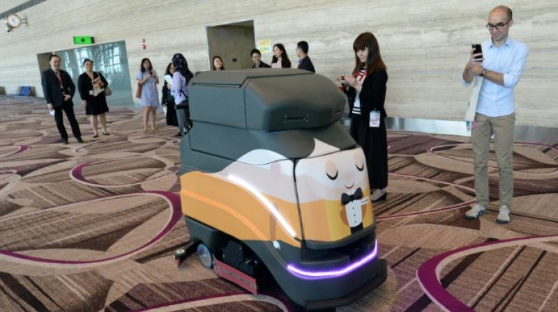 An automatic robot vacuum cleans the floor at Singapores highly regarded Changi airport. (Photo: AFP)