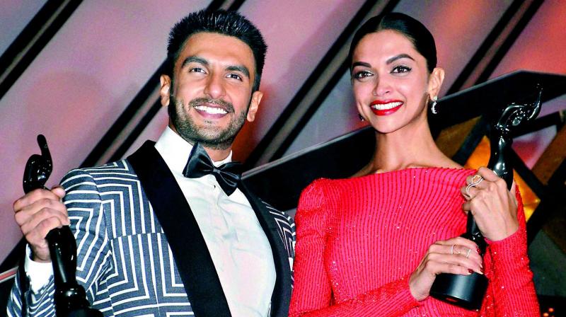 Ranveer Singh and Deepika Padukone pose with the best actor and best actress award, from an awards event last year.