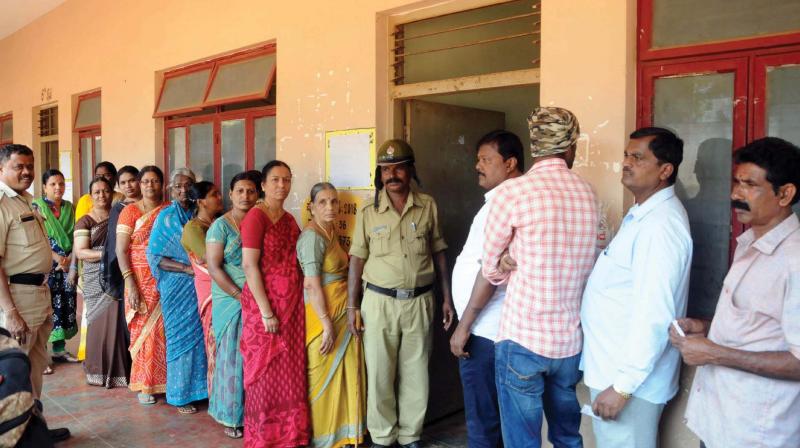 People wait for their turn to vote at a polling booth in Mysuru on Friday 	 KPN