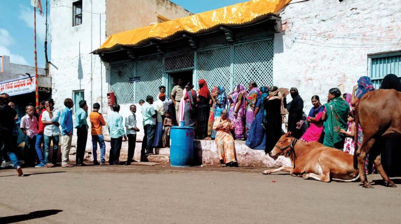 People wait in a queue to cast their votes at booth in Bagalakot on Friday 	 KPN