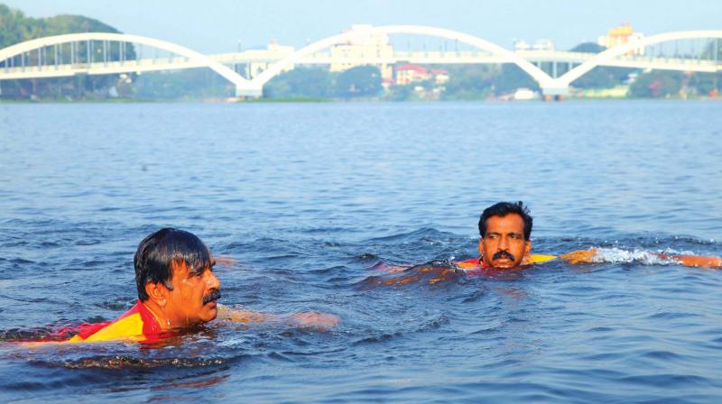 Radhakrishnan (left) swims across Periyar river on Wednesday. (Photo: DC)