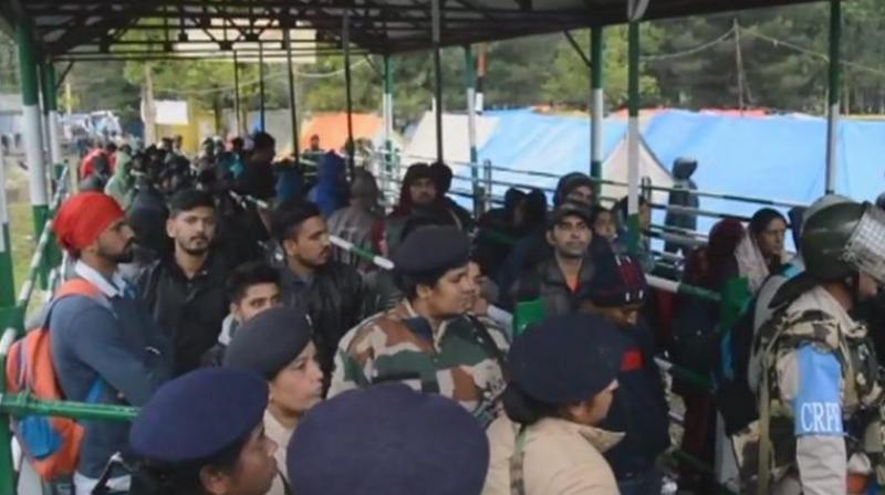 People waiting at one of the base camps after the Amarnath yatra was stalled. (Photo: ANI)