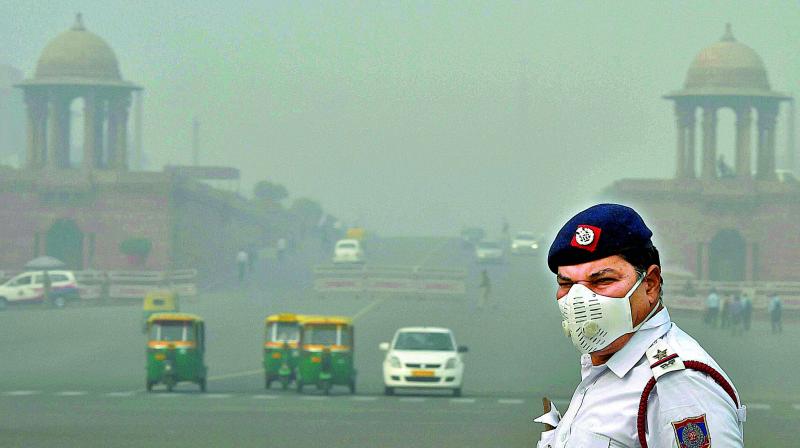 A traffic policeman, wearing an anti-pollution mask,controls traffic amid smog and air pollution which continues to be above dangerous level.