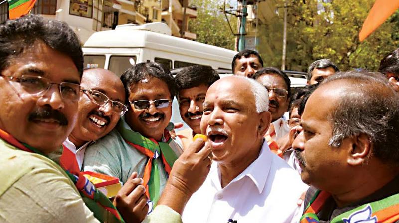 Senior BJP leaders R. Ashok, B.S. Yeddyurappa and P.C. Mohan celebrate partys victory in UP and Uttarakhand assembly elections, in Bengaluru on Saturday 	 DC