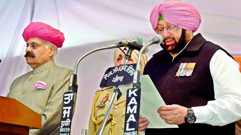 Punjab Governor V.P. Singh Badnore administering oath to the new Punjab Chief Minister Amarinder Singh at the Raj Bhavan in Chandigarh on Thursday. Also sworn into the Cabinet was former cricketer Navjot Singh Sidhu (not in picture), who, as per TV reports, was seen touching Amarinders feet after the event. (Photo: PTI)