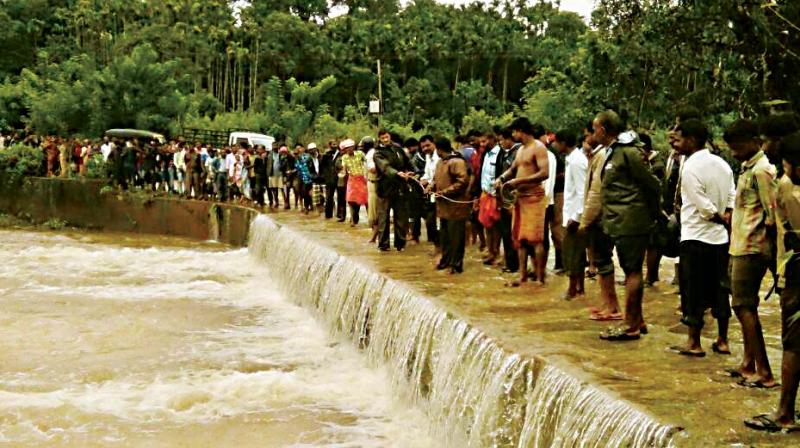 Rescuers search for missing Ashok who is feared to have been washed away in a stream in Koppa in Chikkamagaluru district on Wednesday.