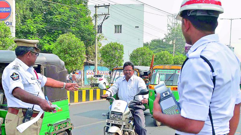 Traffic police stopped two-wheelers, who were not wearing the helmet on Bandar road in Vijayawada on Saturday. (Photo: DC)