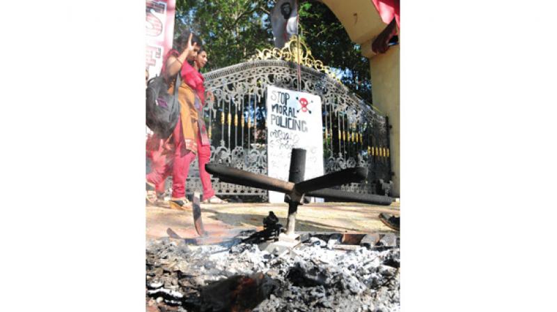 Students walk past the burnt chair of the principal of Maharajas College, Ernakulkam, on Thursday (Photo:  DC)