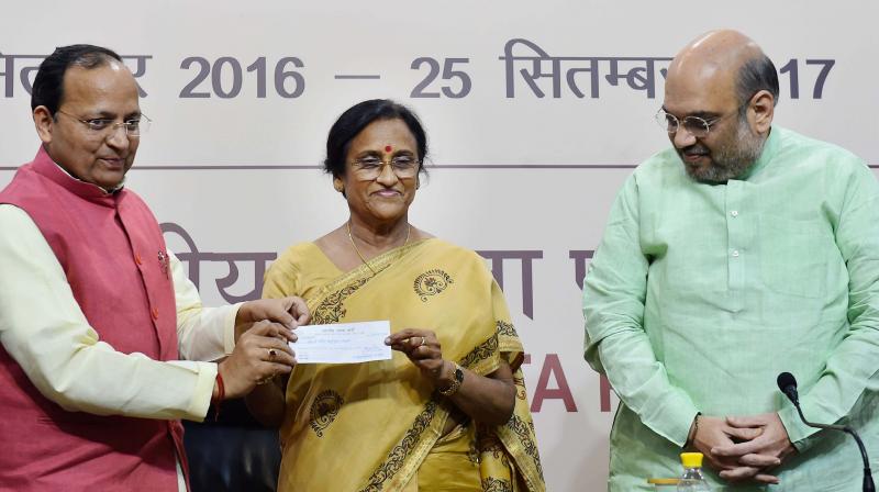 BJP President Amit Shah looks on as party leader Arun Singh shows membership receipt with former UP Congress President Rita Bahuguna Joshi who joined Bharatiya Janata Party at party headquarters in New Delhi. (Photo: PTI)