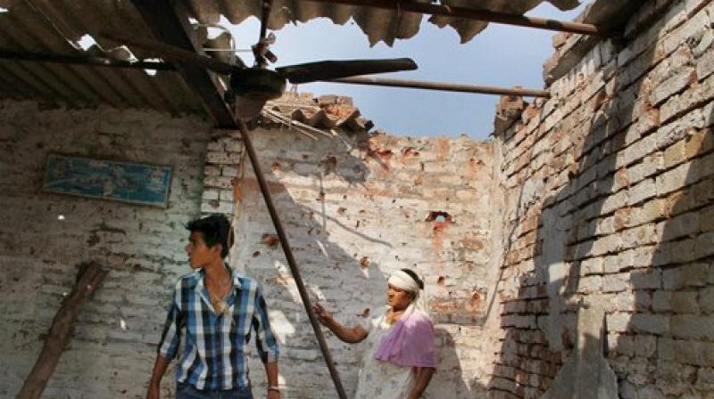 Villagers show a damaged roof house due to alleged shelling from across the LoC at the India-Pakistan International border in Bidipur village of RS Pura sector, about 35km from Jammu, on Wednesday. (Photo: PTI)