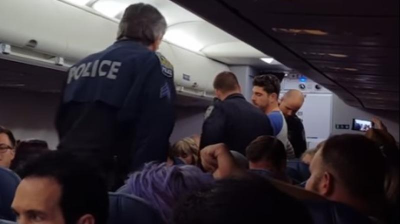Video shot by a passenger shows Fleisig scuffling with another passenger as officers removed him from the plane and Koosmann cursing as officers escorted her off. (Photo: Video grab)