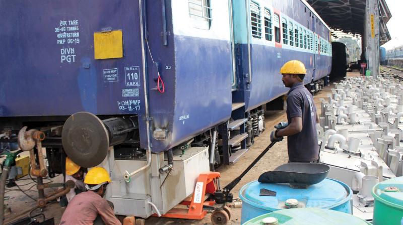 Workers fit bio-toilets to railway coaches at at coaching depot in Mangalore Central railway station