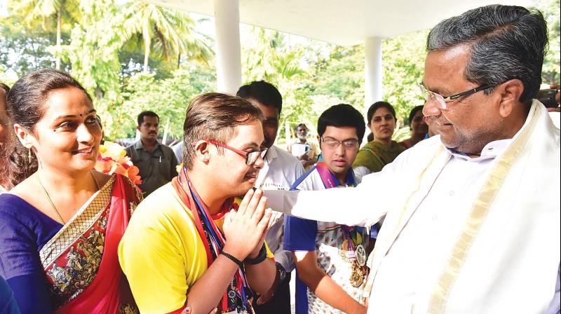 Chief Minister Siddaramaiah honours specially abled children who won several international medals in  sports and games, at his residence in Bengaluru on Wednesday. (Photo: DC)