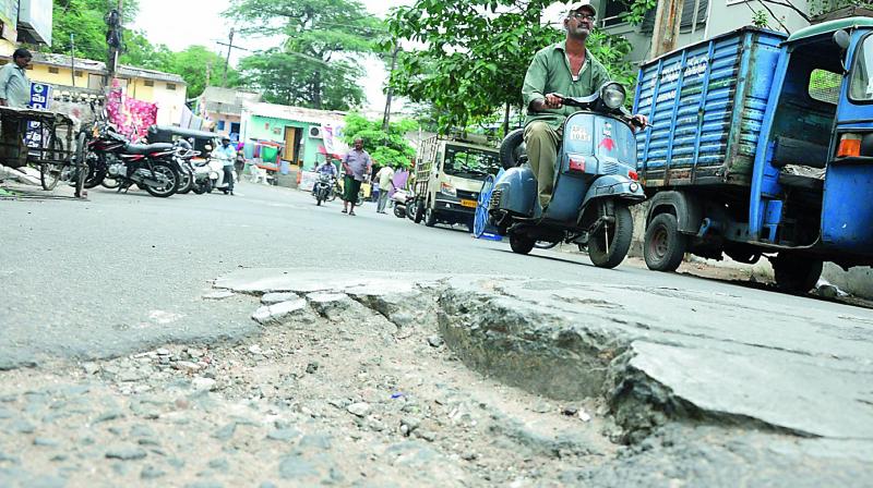 Damaged road near a manhole poses threat to motorists at Dandu Bazaar area in Visakhapatnam on Wednesday. (Photo: DC)