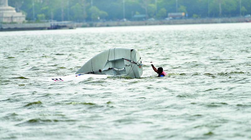 A sailor tries to get his toppled boat back on water during practice ahead of the Hyderabad Sailing Week competitions at the Hussainsagar Lake on Tuesday. (Photo: DC)
