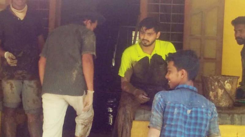 Students clean the compound of one of their class mate in Elanthoor, Pathanamthitta.