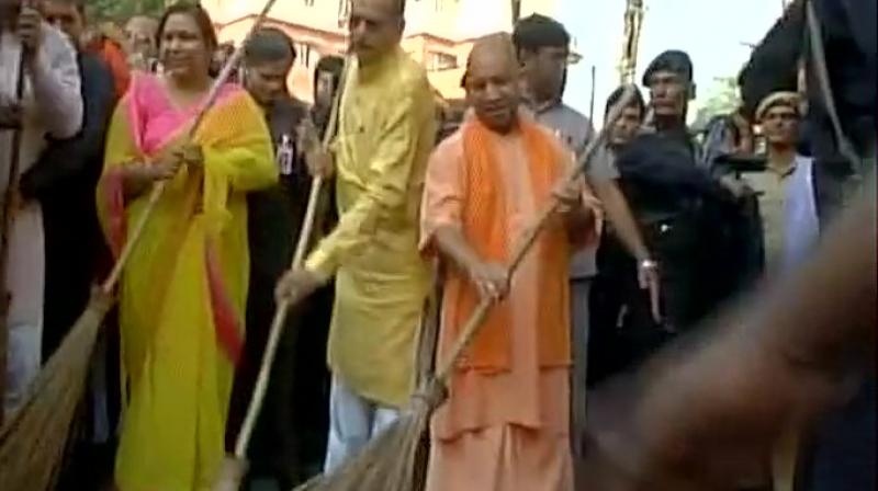 Chief Minister Yogi Adityanath on Saturday picked up a broom in Lucknow to convey his seriousness towards making Uttar Pradesh clean. (Photo: ANI/Twitter)