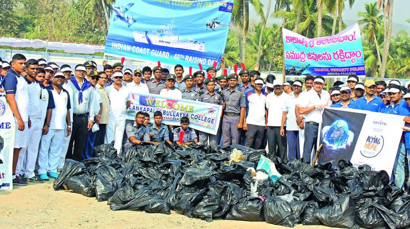 NCC cadets and Indian Coast Guard personnel pose for a group photograph during the Special Coastal Clean Up drive as part of the 40th Raising Day Celebrations of the Indian Coast Guard at Rushikonda beach on Saturday.