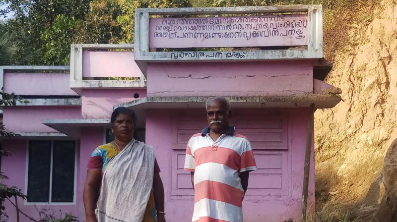 Joseph and Alice in front of their flood-ravaged house at Vellathooval in Idukki. On the wall of the house, it is written that he is ready to sell his kidney for rebuilding the house that was destroyed in landslide.