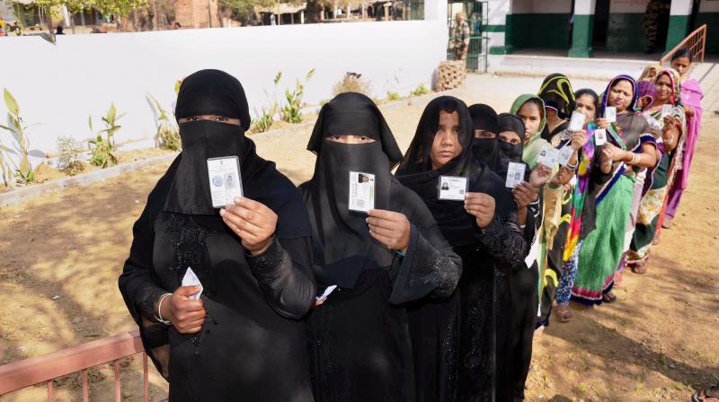 Muslim women line up at a polling station in Mirzapur to cast their votes during the seventh and final phase of the Uttar Pradesh Assembly elections. (Photo: PTI)