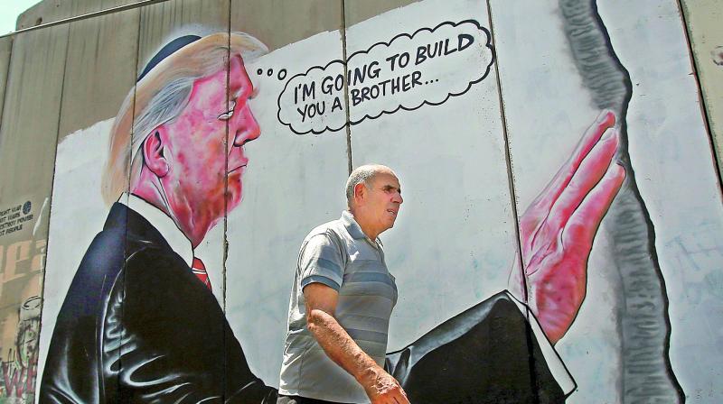 Has Banksy struck again in familiar territory? Two murals showing an oversized President Donald Trump appeared on Israels West Bank separation barrier, yards from where the elusive artist decorated a hotel earlier this year. (Photo: AFP)