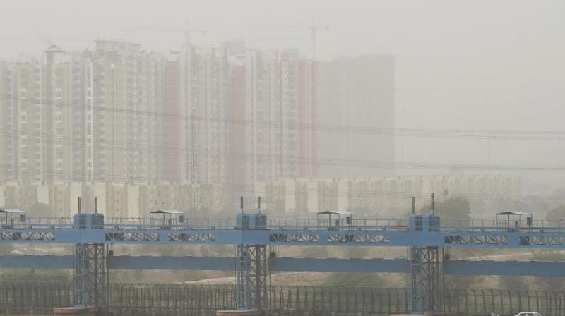 Vehicles cross a barrage on Hindon river as dust covers the skyline in Ghaziabad.  (Photo: AFP)