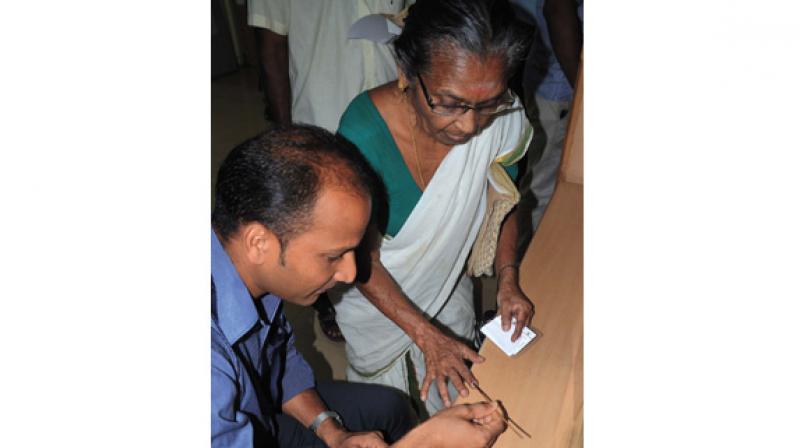 A bank official applies ink on a customers finger in Thiruvananthapuram on Thursday. (Photo: DC)