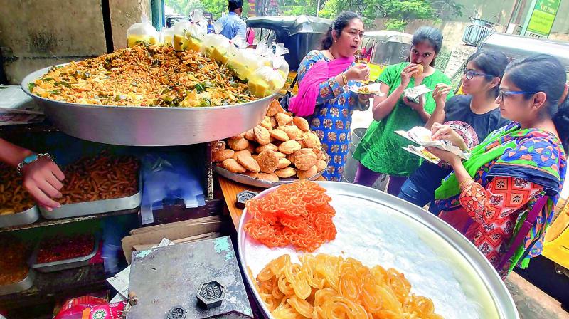 Woman enjoy a quick snack at one of the bandis in Hyderabad on Wednesday. (Photo: DC)