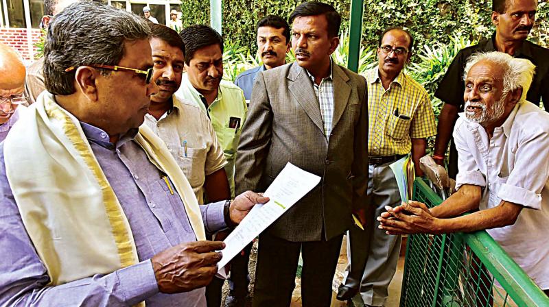 Chief Minister Siddaramaiah receives a petition from an elderly person during Janata Darshan in Bengaluru on Tuesday  	 KPN