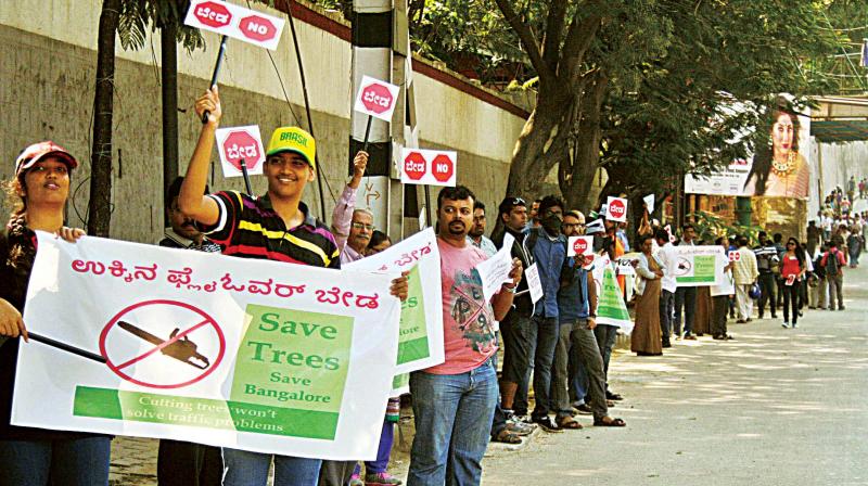 Volunteers form a human chain to protest against the proposed steel flyover from Chalukya Circle to Hebbal, in Bengaluru on Sunday (Photo:DC)