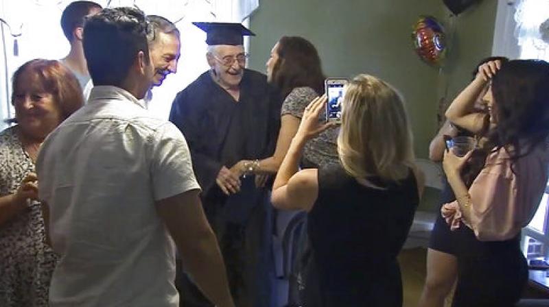 In this image from video provided by WPVI, Charles Leuzzi, center, a 97-year-old World War II veteran, is congratulated by friends and relatives after receiving an honorary high school diploma from the School District of Philadelphia on Sunday, July 16, 2017, in Philadelphia. (Photo: AP)