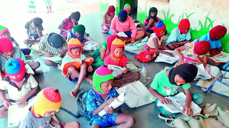 School students attending class wearing the monkey caps bought by their teacher Kodipaka Ramesh in a remote school in Mahabubabad district.