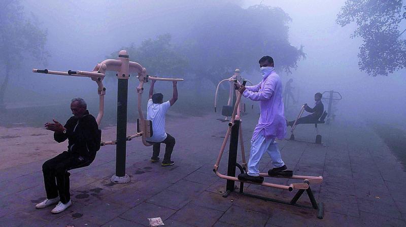 Braving the pollution, people seen doing exercise at a public park in New Delhi on Wednesday morning. (Photo: PTI)