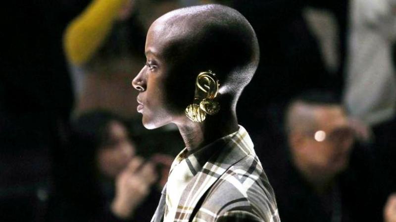 Gold-cast ear covers gave a theatrical accent to the masculine collection of Gucci. (Photo: AP)