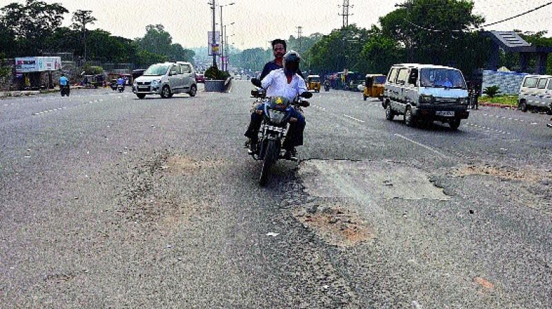 Motorists try to negotiate the dangerous patch of the road near DRDL, Santoshnagar, where a 33-year-old man died on Sunday. 	(Photo: DECCAN CHRONICLE)