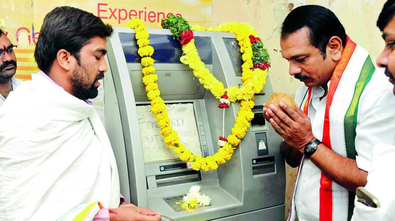 With ATMs not working in the city, Congress ex-MLA Sudheer Reddy offers puja in the presence of pandits and party workers at Andhra Bank ATM in Kothapet.