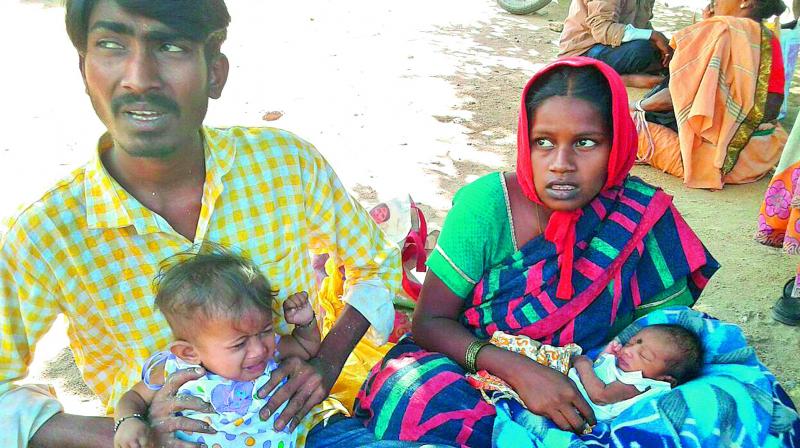 Santosh, 25, with his wife and two children, sits outside Gandhi Hospital. (Photo: DC)