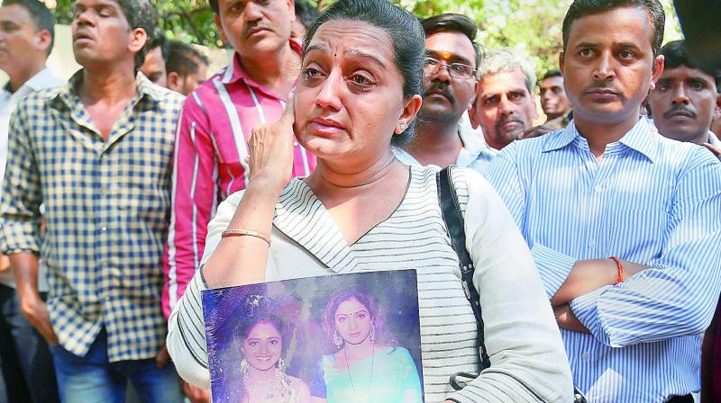 Fans of Sridevi wait outside her residence at Lokhandwala Complex, in Andheri, Mumbai on Sunday.