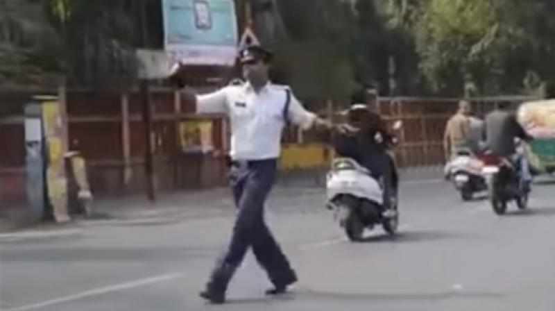 Heads turn and drivers cannot fail to notice when the 38-year-old moonwalks across busy intersections. (Youtube Screengrab)