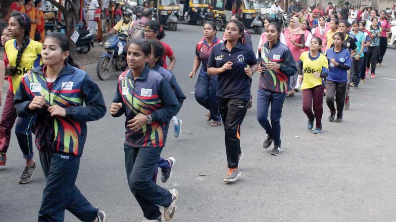 Girls participate in a mass  run organised by the District Sports Council as part of the womens wall in Kozhikode on Friday. (Venugopal)