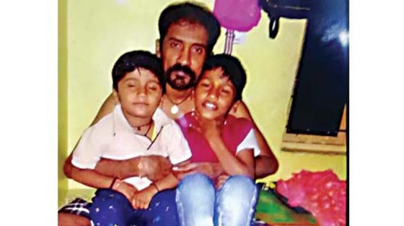Chandrashekhar with his disabled son, Lokeshwar (left). The garment worker smothered his son to death before hanging himself 	(Photo: DC)